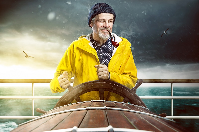 Charmanter Kapitän zur See steuert sein Schiff