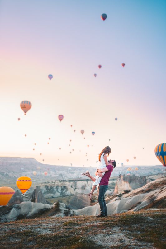 Paar feiert ihre Beziehung mit Luftballons im Hintergrund
